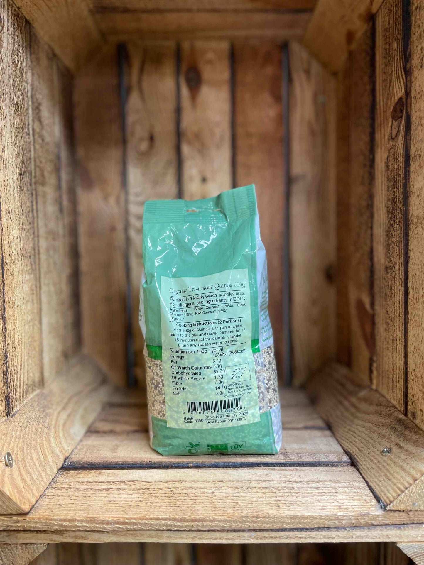 Organic Tri-Colour Quinoa package on wooden shelf, showcasing nutrient-rich blend for versatile cooking.