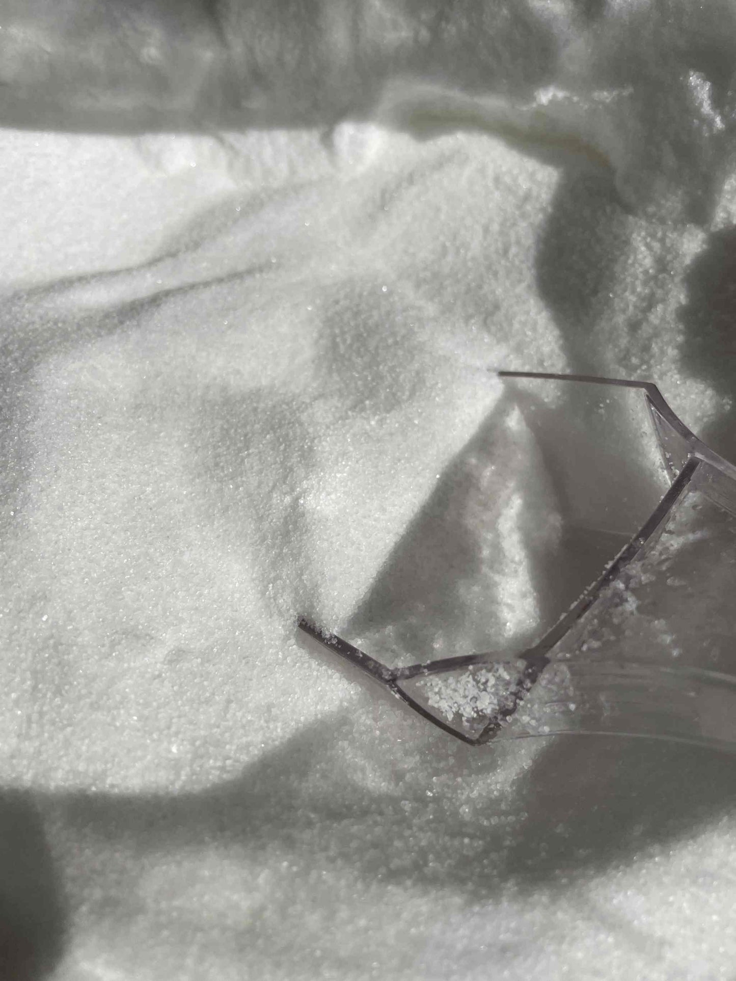 Citric acid food grade loose powder with scoop in container.