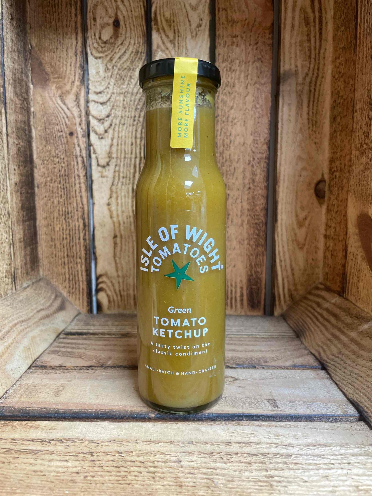 Green Tomato Ketchup IOW Tomatoes in a bottle on a wooden background.