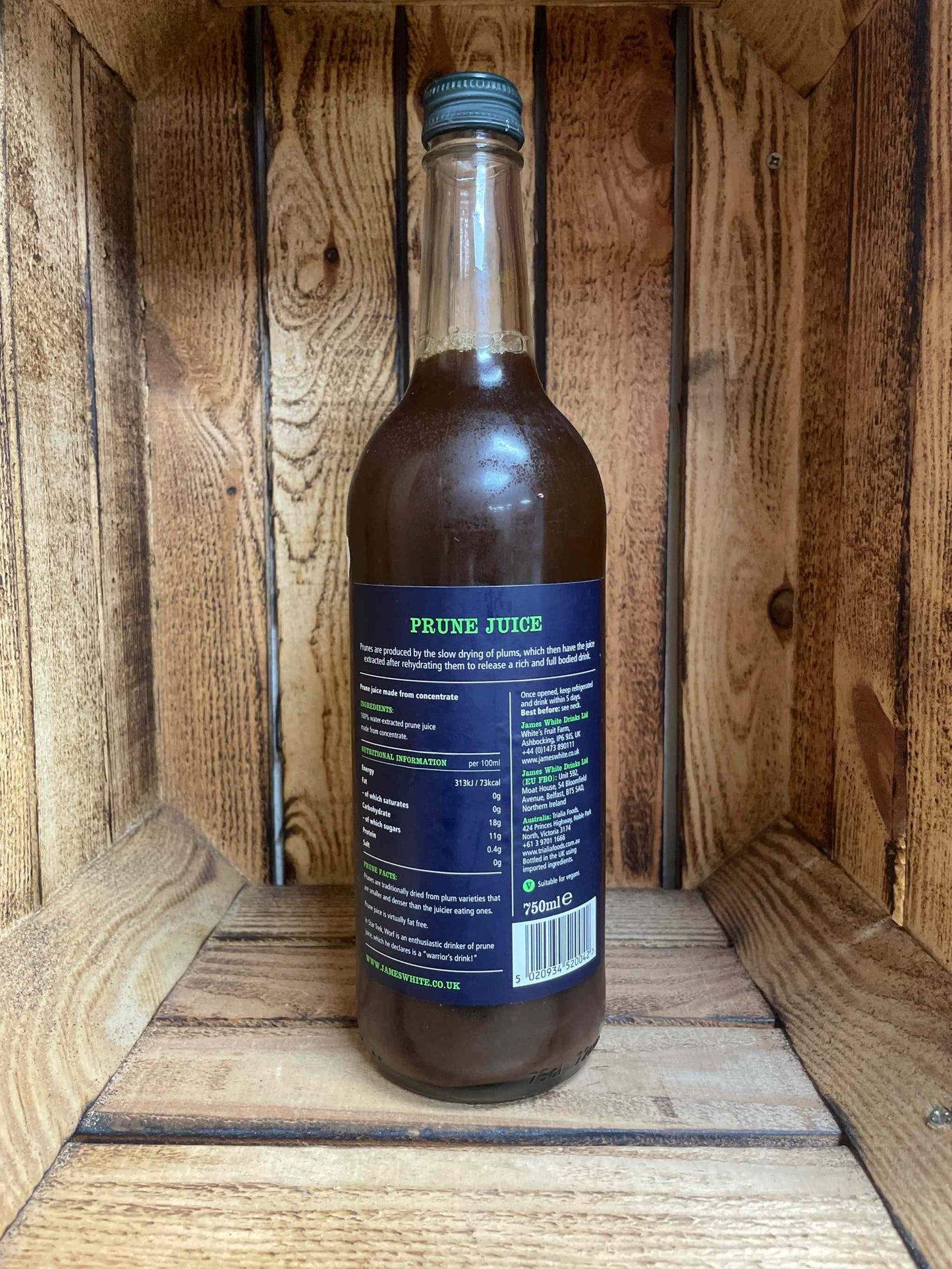 James White Juice Prune bottle displayed on wooden background.
