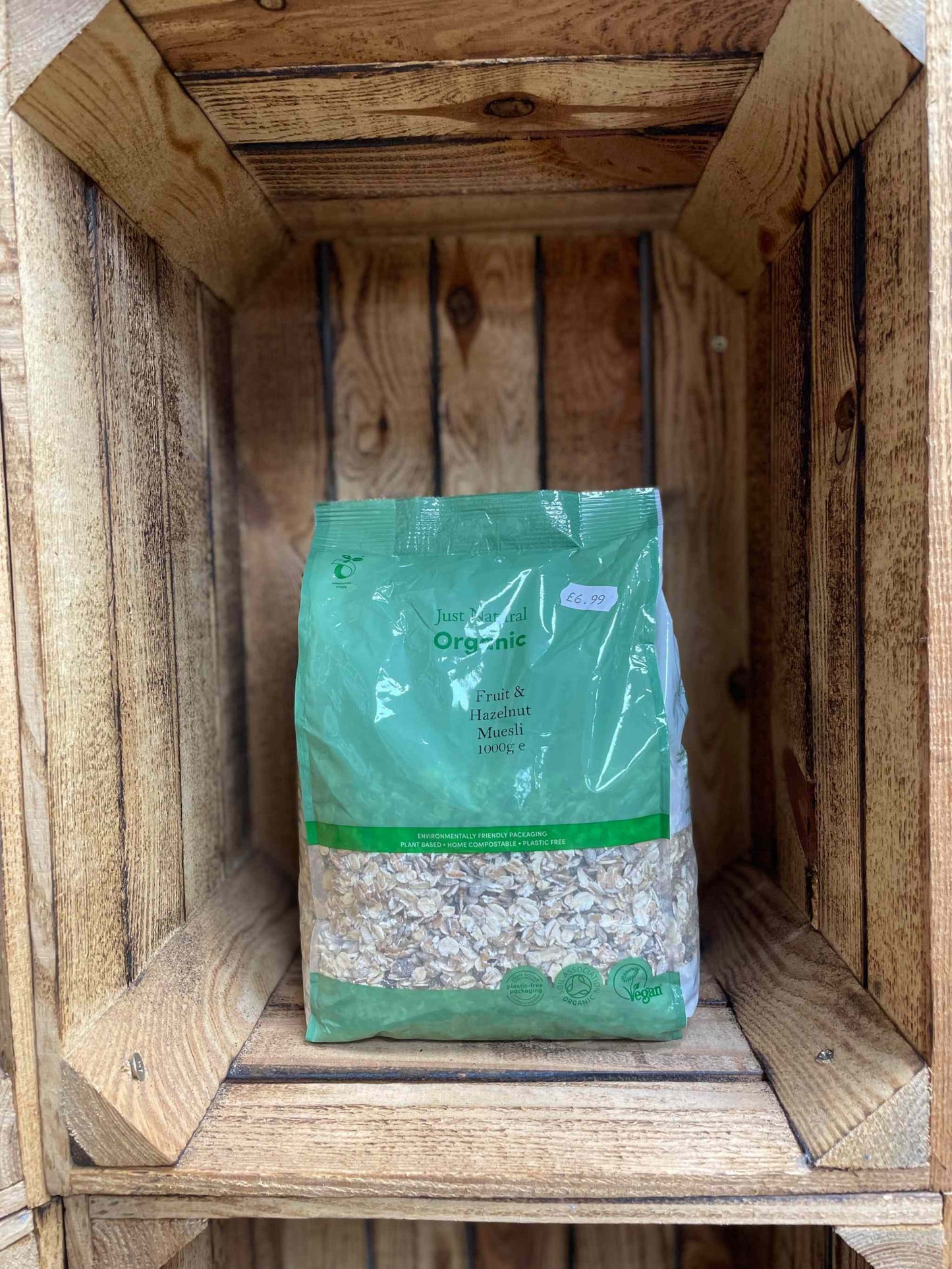 Organic Fruit and Hazelnut Muesli 1kg pack on wooden shelf, healthy breakfast option.