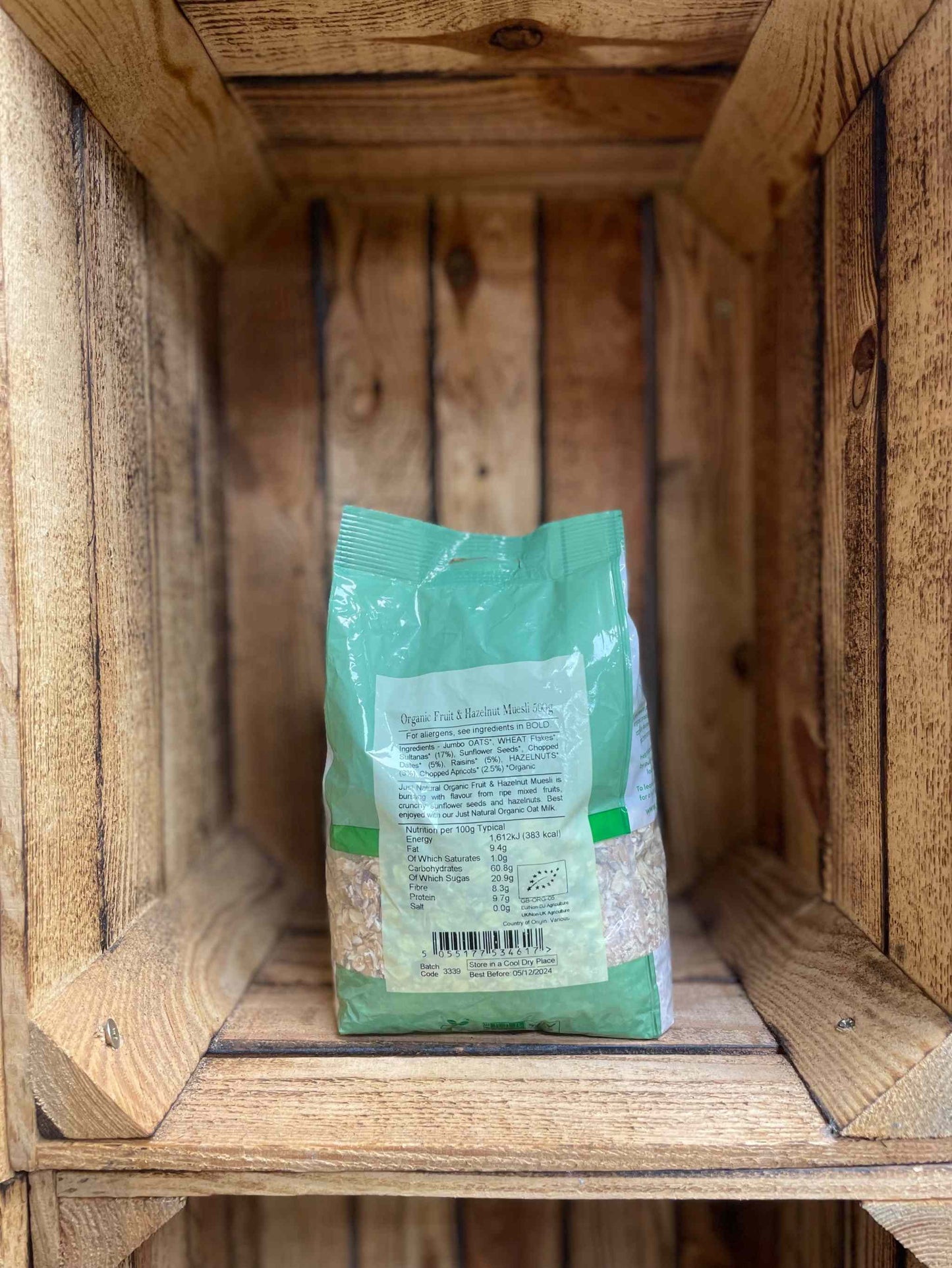 Organic Fruit and Nut Muesli 500g package in a rustic wooden box.
