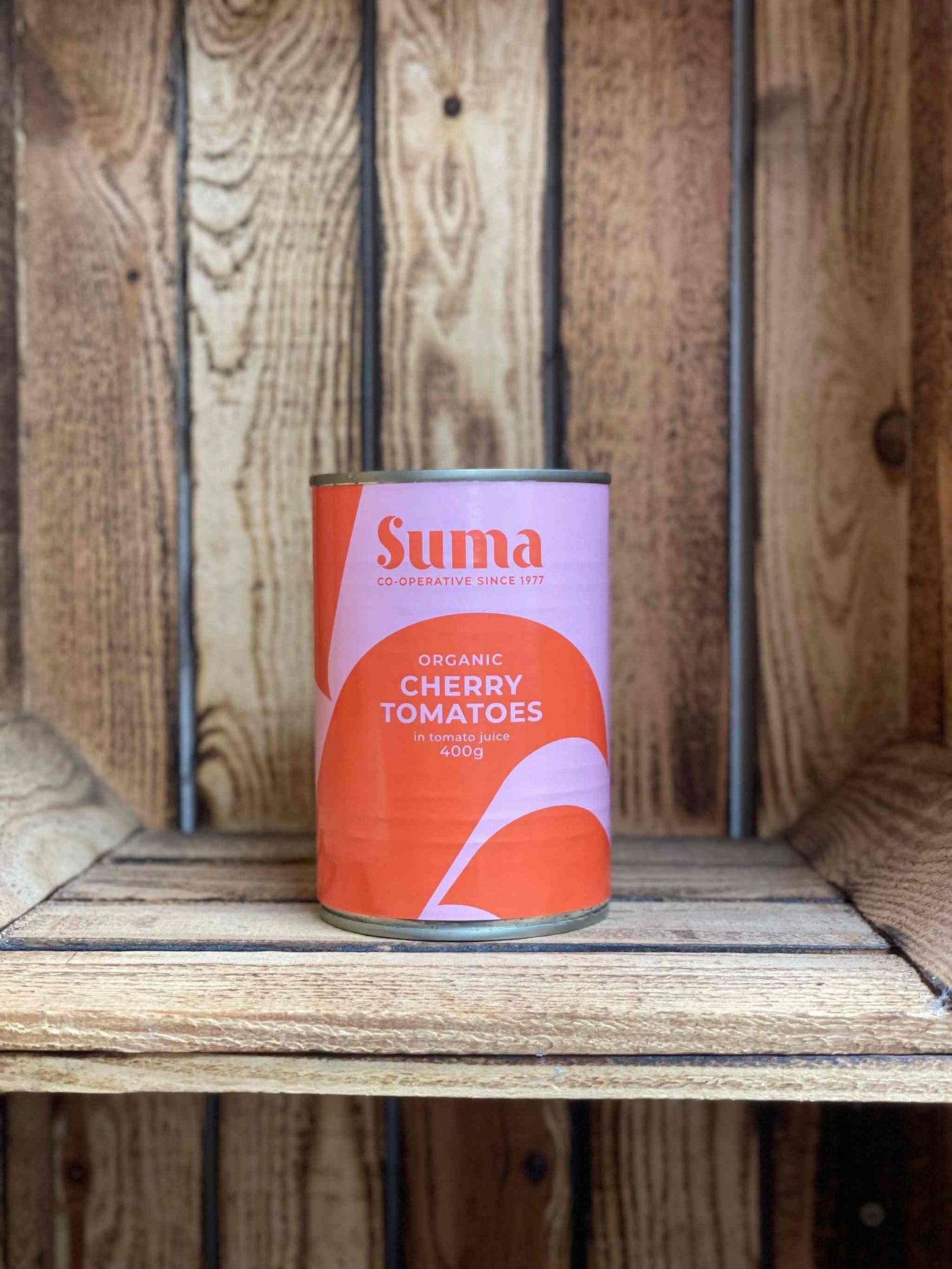 Organic cherry tomatoes in a can on a wooden shelf.