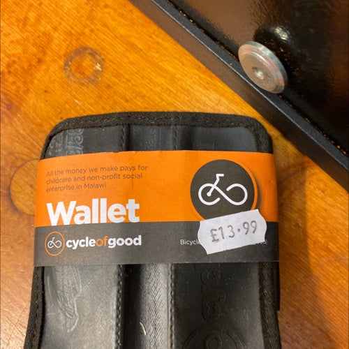 Cycle of Good wallet on a wooden surface with a price tag of £13.99.