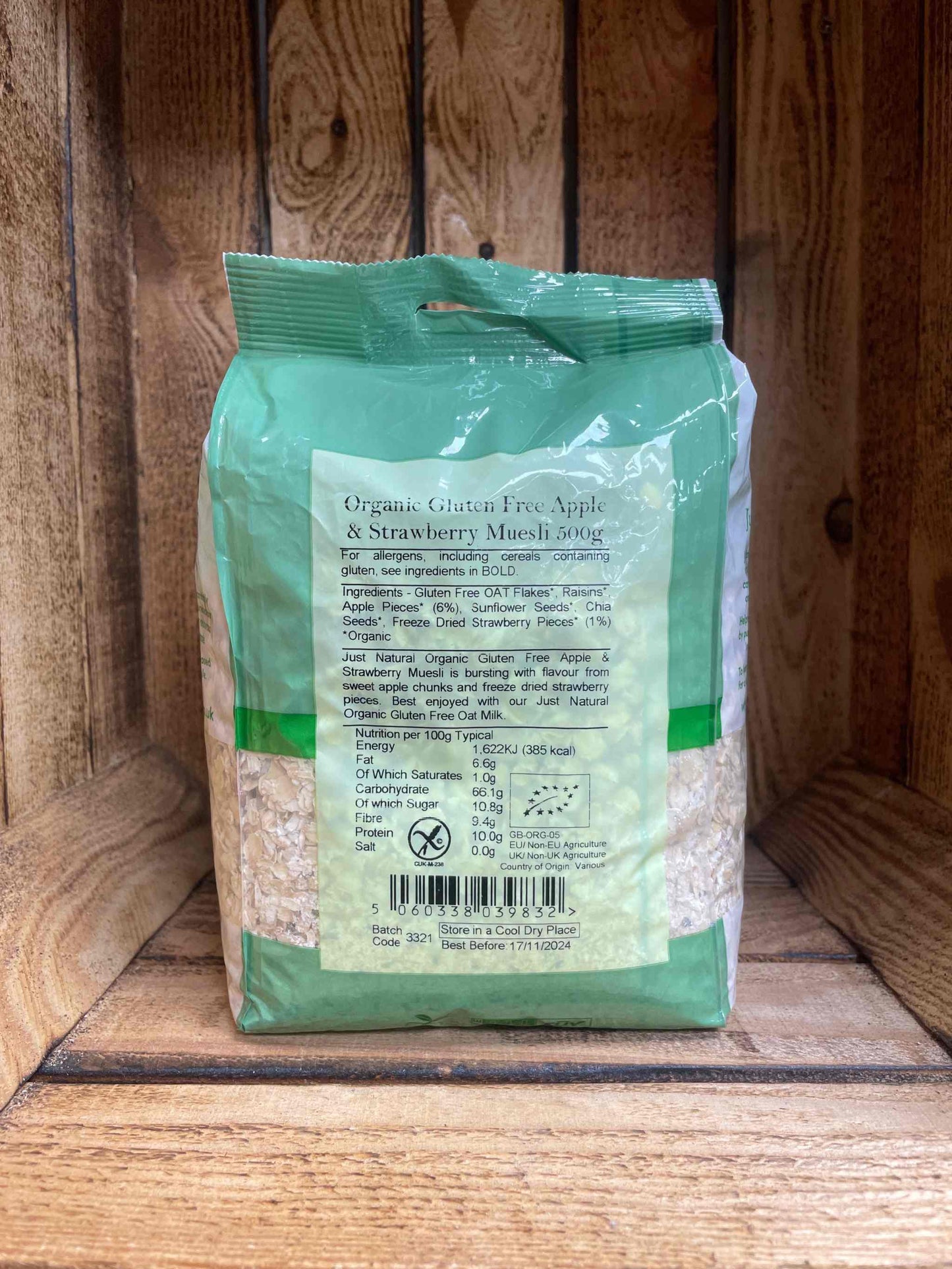 Organic GF Apple and Strawberry Muesli 500g on wooden shelf.