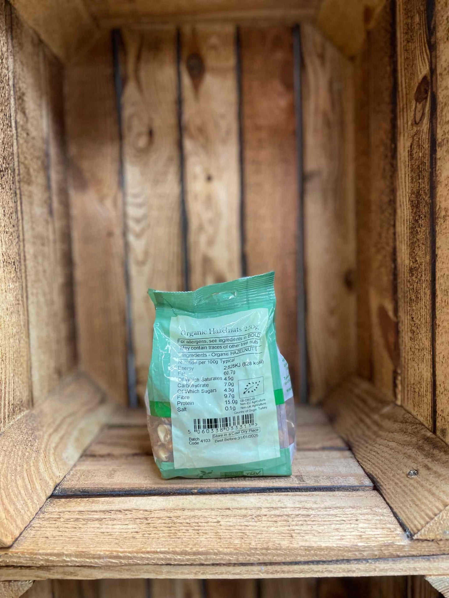 Organic Hazelnuts 250g package in a wooden crate.