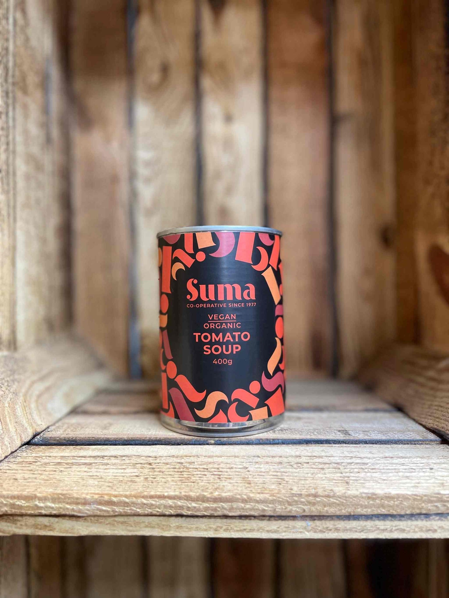 Suma Tins & Jars Organic Tomato Soup 400g can on wooden shelf.