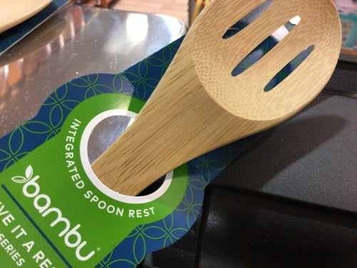 Bamboo slotted spoon with integrated rest for sustainable cooking.