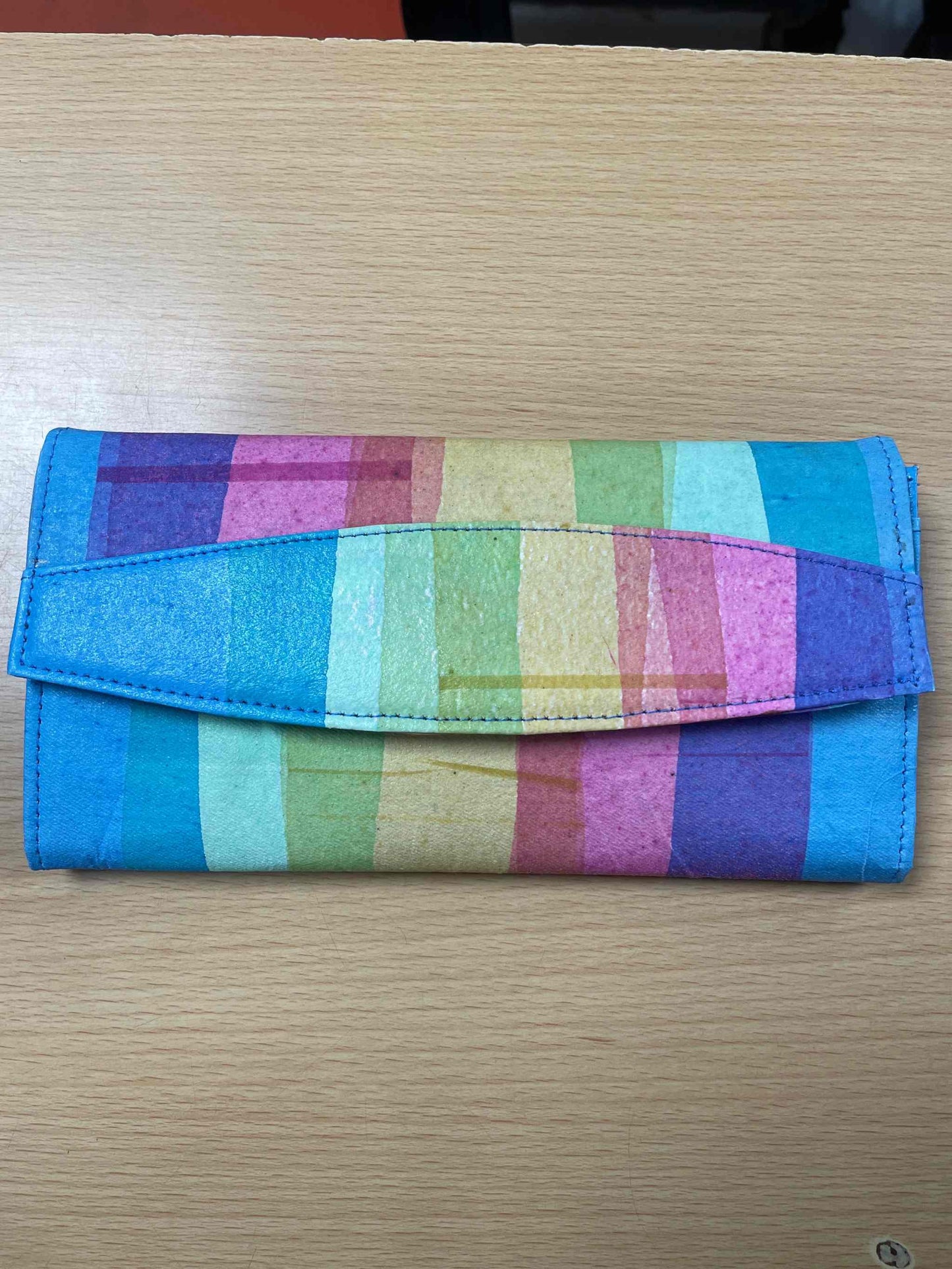 Rainbow clutch purse made from recycled plastic with vibrant colors, eco-friendly and handcrafted.