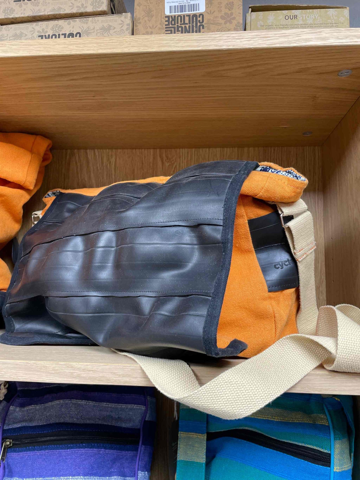 Versatile cycle shoulder bag with weather-resistant design, orange and black color, and durable construction.