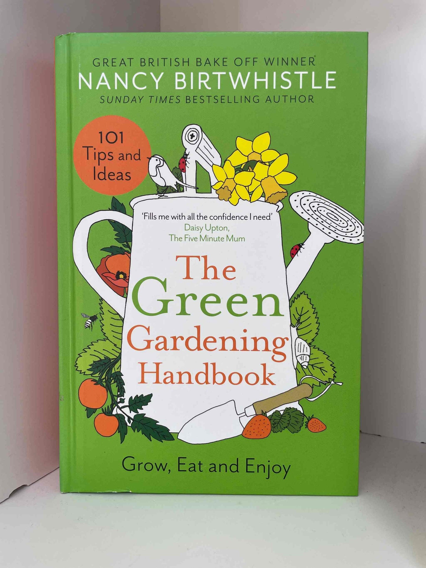 The Green Gardening Handbook cover featuring gardening illustrations and 101 tips for a thriving garden.