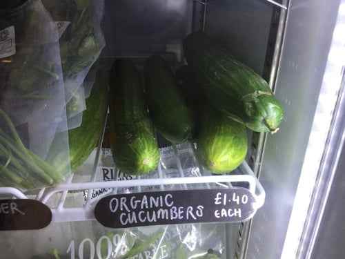 Organic cucumbers in a fridge priced at £1.40 each.