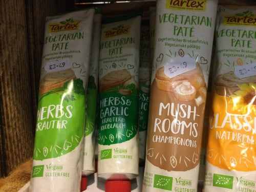 Tartex vegan pate tubes with assorted flavors on a shelf.