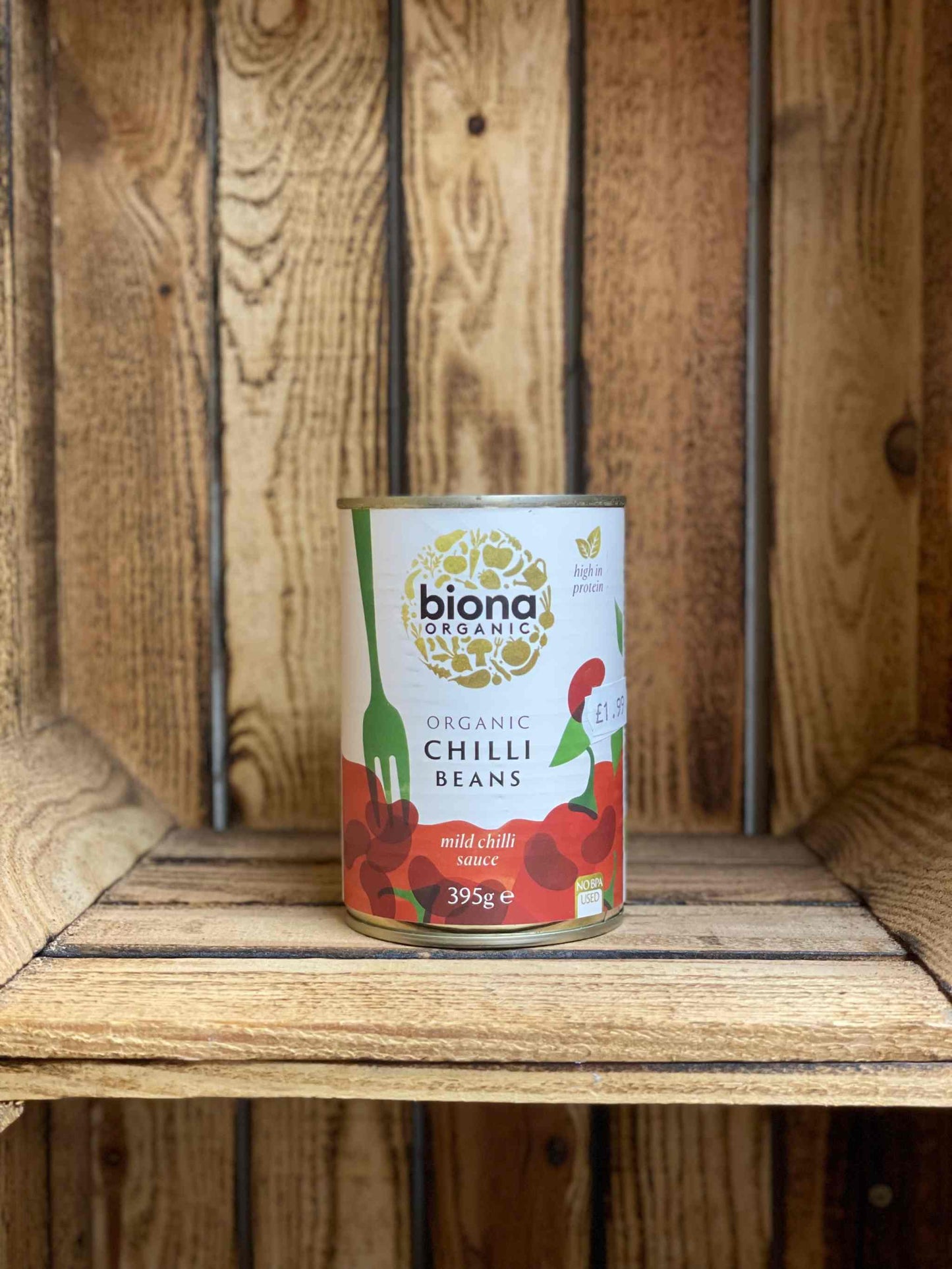 Organic Chilli Black Beans can on rustic wooden shelf.