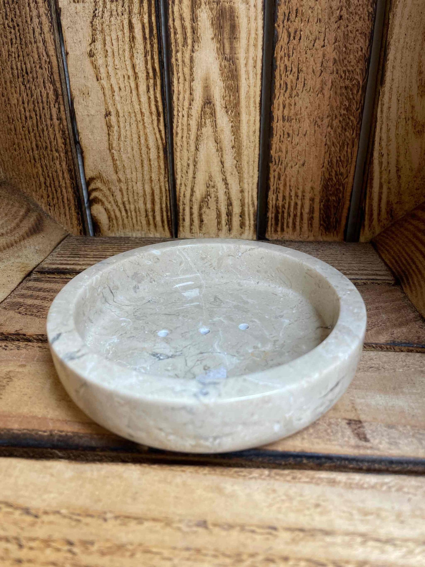 Soapstone hand made XL round soap dish on wooden surface.