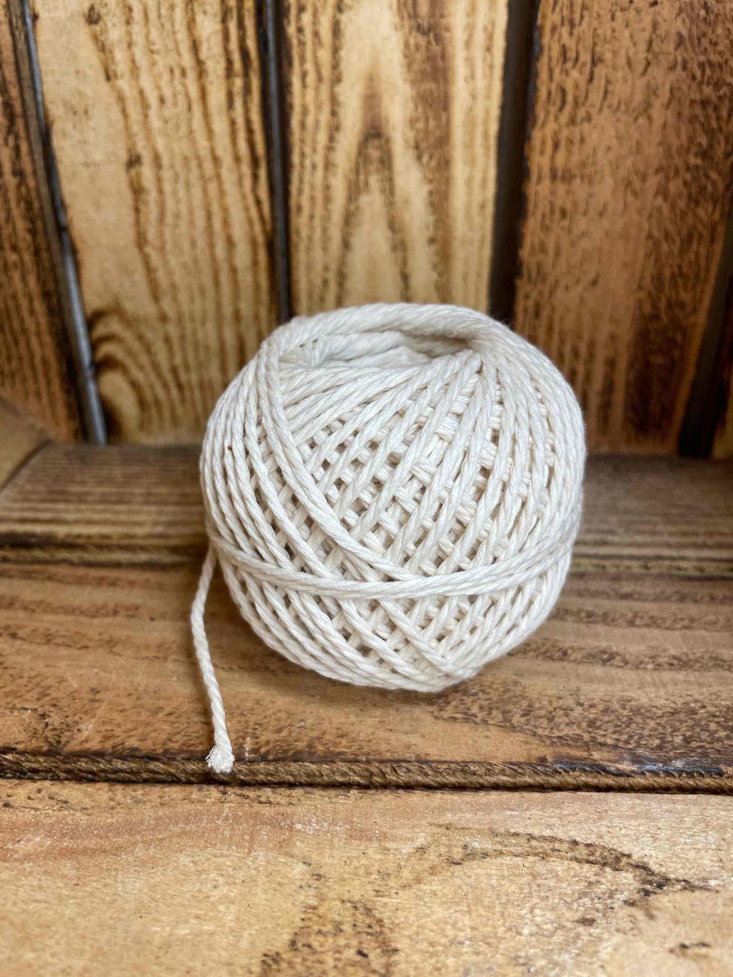 Natural twine refill on wooden surface, eco-friendly and biodegradable, ideal for crafting and gift wrapping.