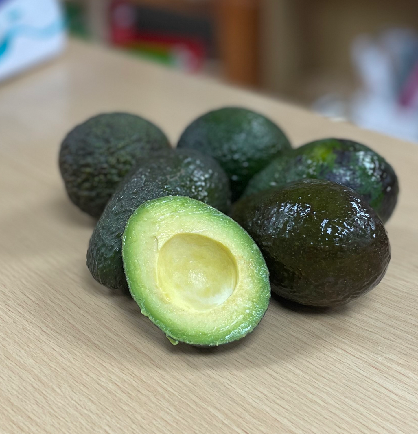 Organic avocados on a table, one cut open to show creamy texture.