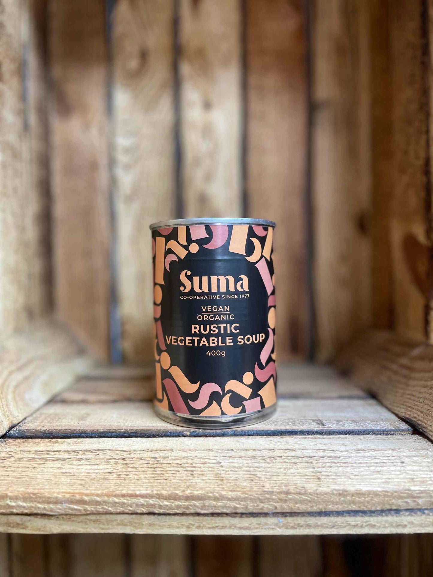 SUMA Tins & Jars Coconut Milk in rustic packaging on a wooden shelf.