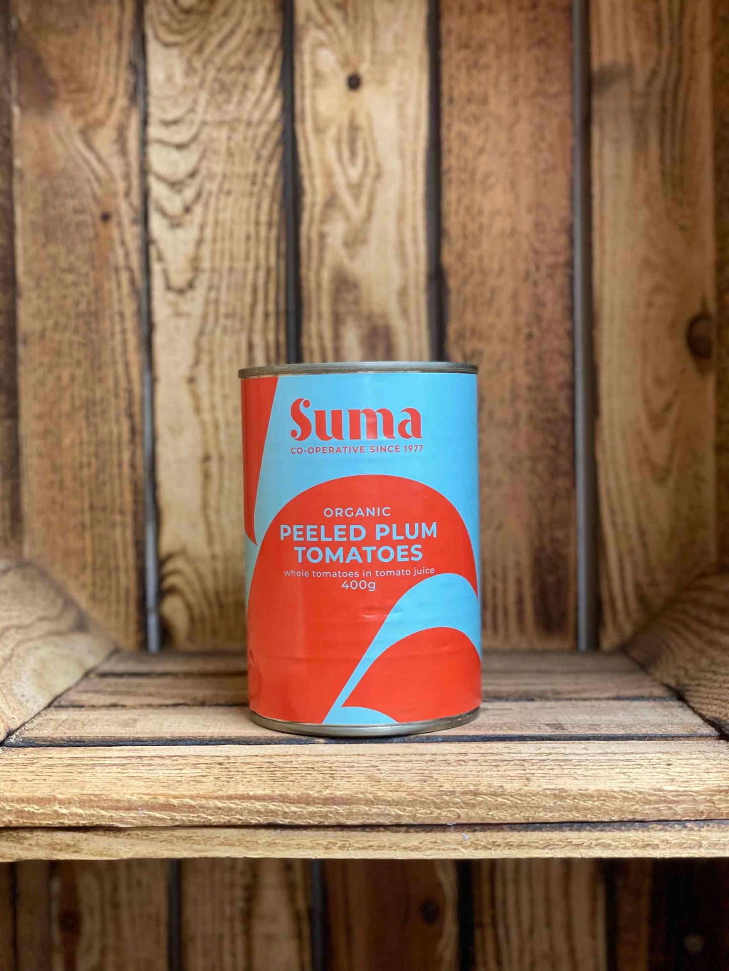 Suma Tins & Jars on rustic wooden shelf.