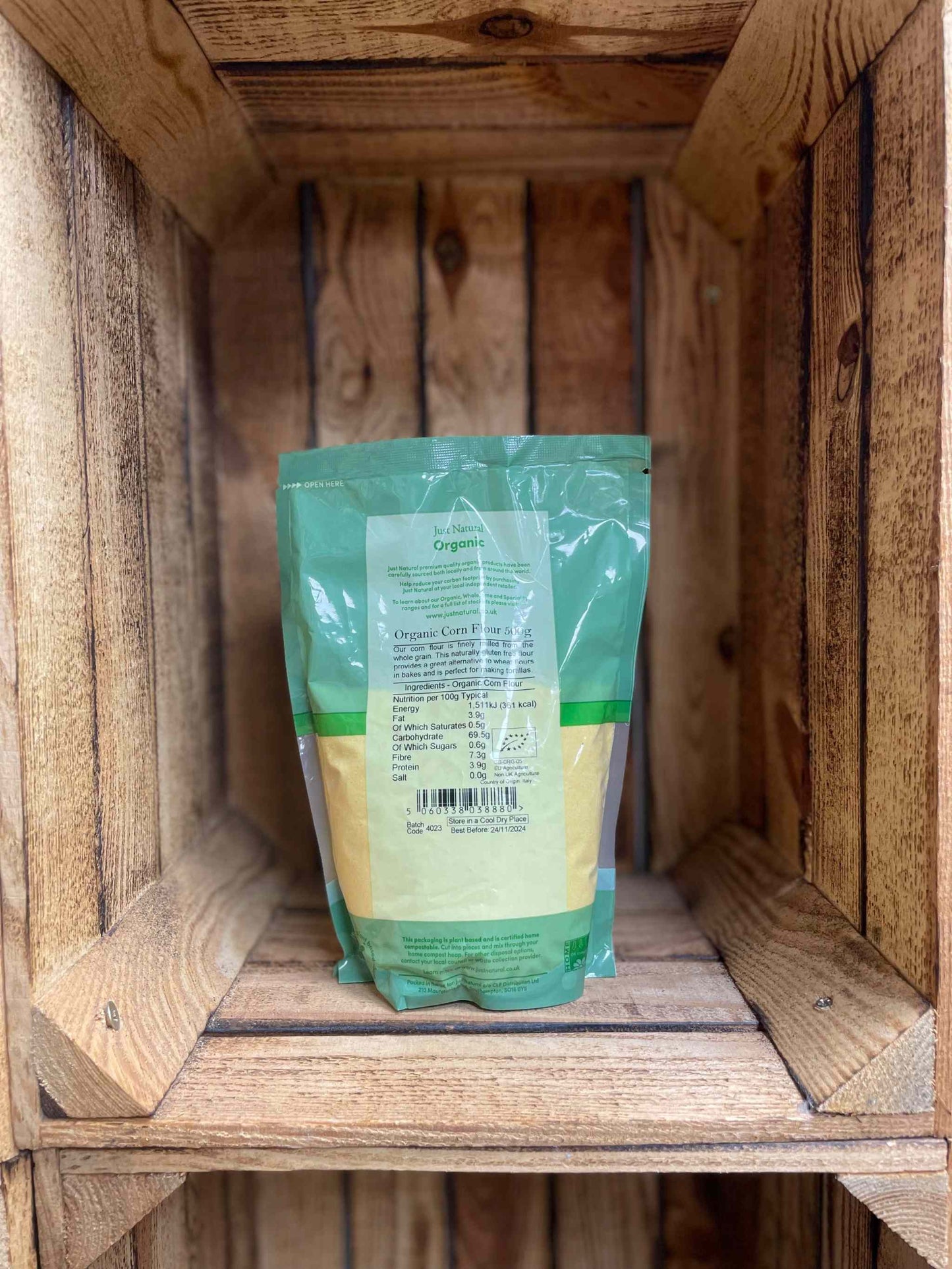 Organic Corn Flour 500g in eco-friendly packaging on a wooden shelf.