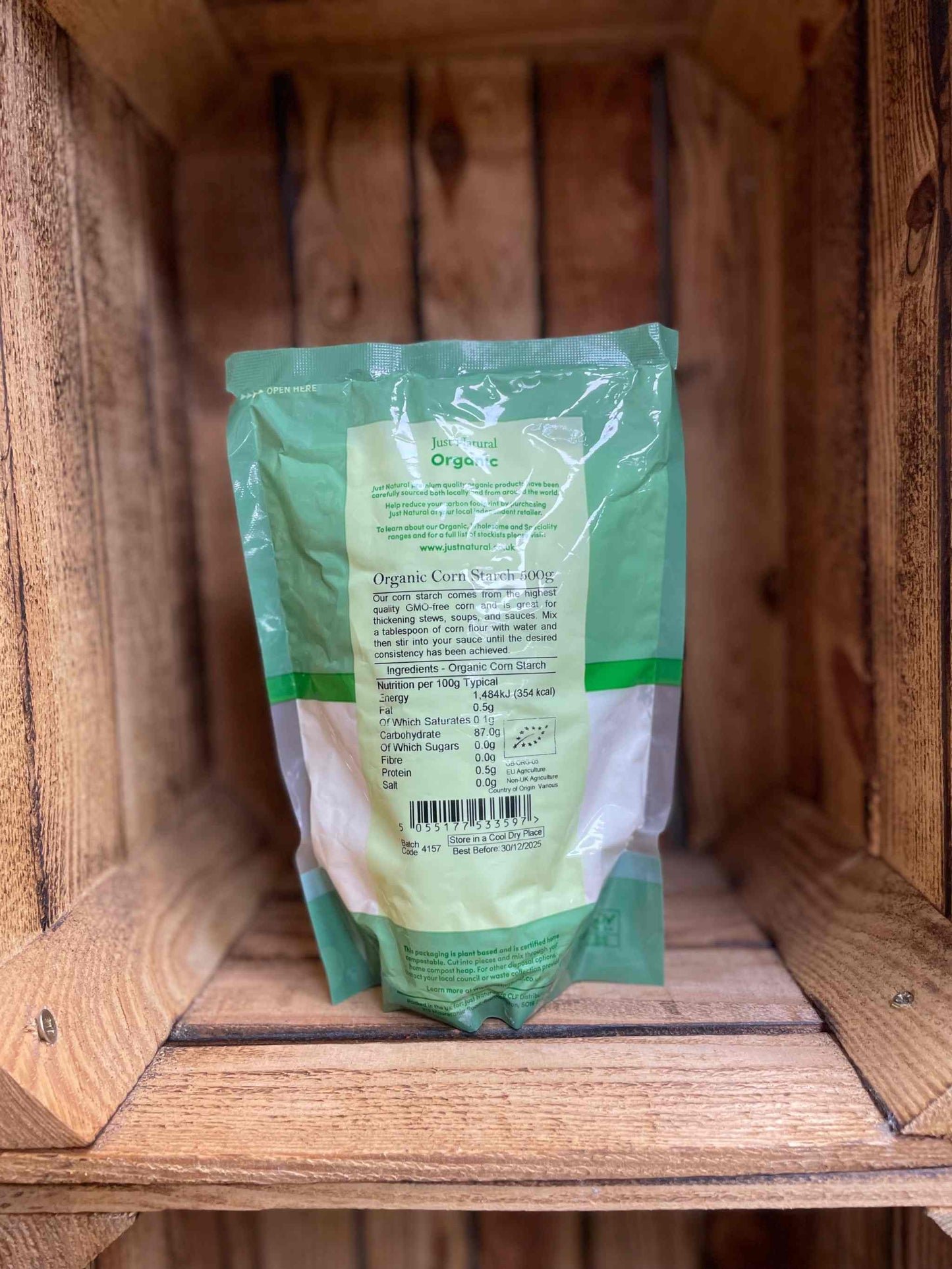 Organic corn starch 500g pack on wooden shelf, ideal for gluten-free cooking and baking.