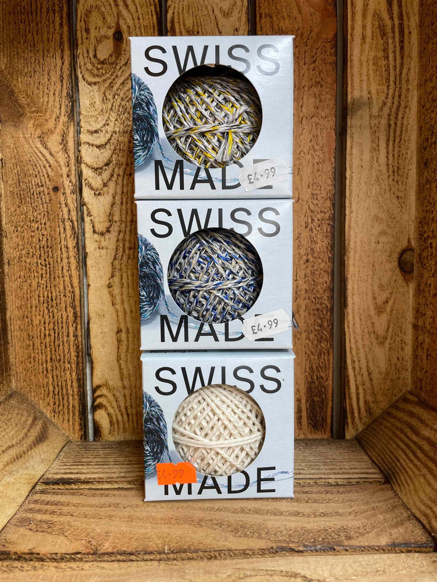 Recycled natural cotton twine in box on wooden shelf, eco-friendly crafting essential.