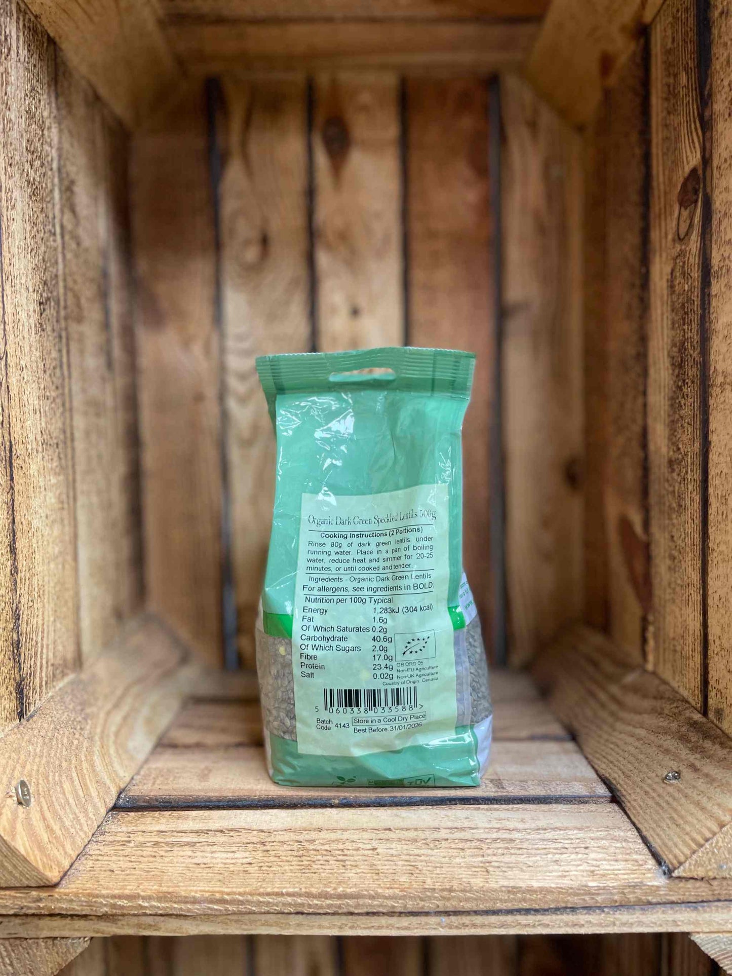 Organic Dark Green Lentils 500g in eco-friendly packaging on wooden shelf.