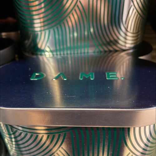 Compact Dame tin with sleek metal design and stylish pattern.