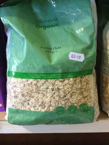 Organic Jumbo Oats 1kg in eco-friendly green packaging displayed on shelf.