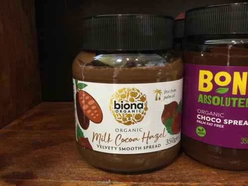Biona Milk Cocoa Hazel Chocolate Spread jar on a shelf, organic and velvety smooth.