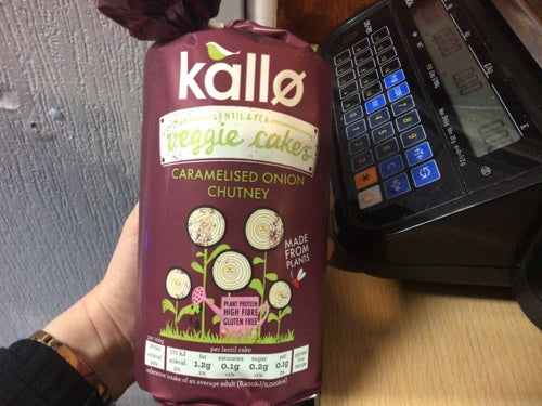 Kallo Cakes with Caramelised Onion Chutney packaging in hand, featuring natural ingredients and convenient design.