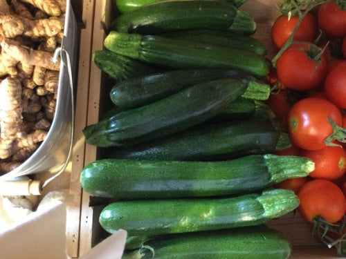 Organic courgettes displayed in a market setting, highlighting their vibrant green color and freshness.