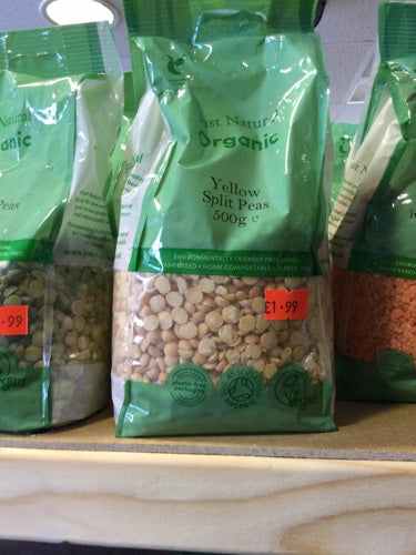 Organic green split peas 500g package on a shelf with price tags.