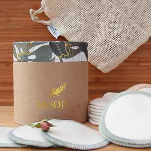 Mooju beauty box with reusable cotton pads and storage bag on a wooden surface.