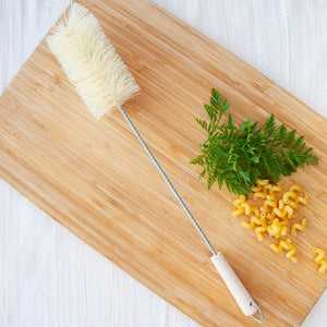 EcoLiving bottle brush with durable bristles and ergonomic handle on a wooden board.