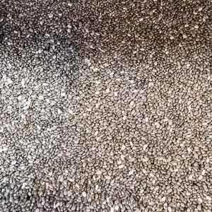 Close-up of chia seeds (100g) showing texture and detail. Nutrient-rich superfood for healthy recipes.