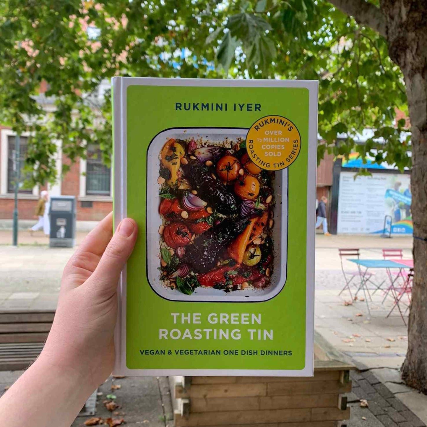 The Green Roasting Tin cookbook by Rukmini Iyer held outdoors, vegan and vegetarian one dish dinners.