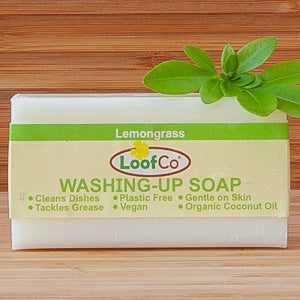 Lemongrass Washing-Up Soap Bar by LoofCo on wooden background with green leaves.