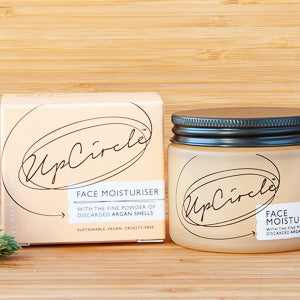 UpCircle face moisturiser in recyclable glass jar on wooden surface.