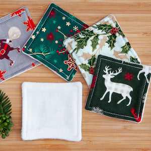 Festive eye make-up pads with holiday-themed designs on a wooden surface.