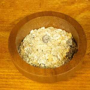 Fruit crunch muesli 100g in a wooden bowl showcasing oats and dried fruits.