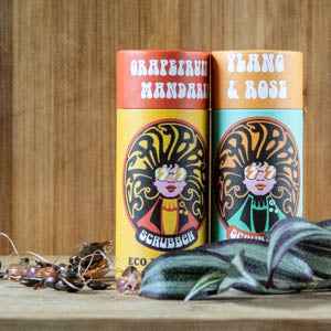 Scrubber Deodorant Grapefruit & Mandarin and Ylang & Rose packaging on wooden background.