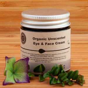 Heavenly Organics Eye and Face Cream with rose geranium on wooden background.