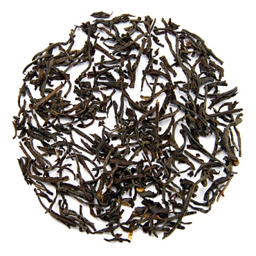 Supreme English Breakfast Tea leaves scattered on a white background.