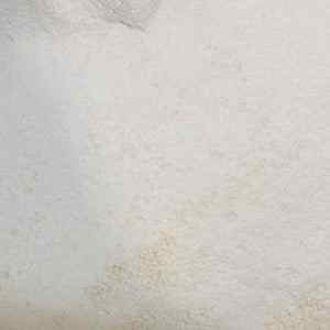 Sesi washing powder 100g on a white surface, showcasing its fine texture.