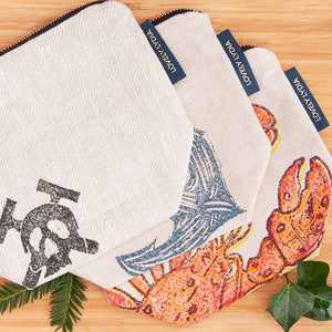 Skull and Crossbones Washbag by Lovely Lydia with vibrant design on a wooden surface.