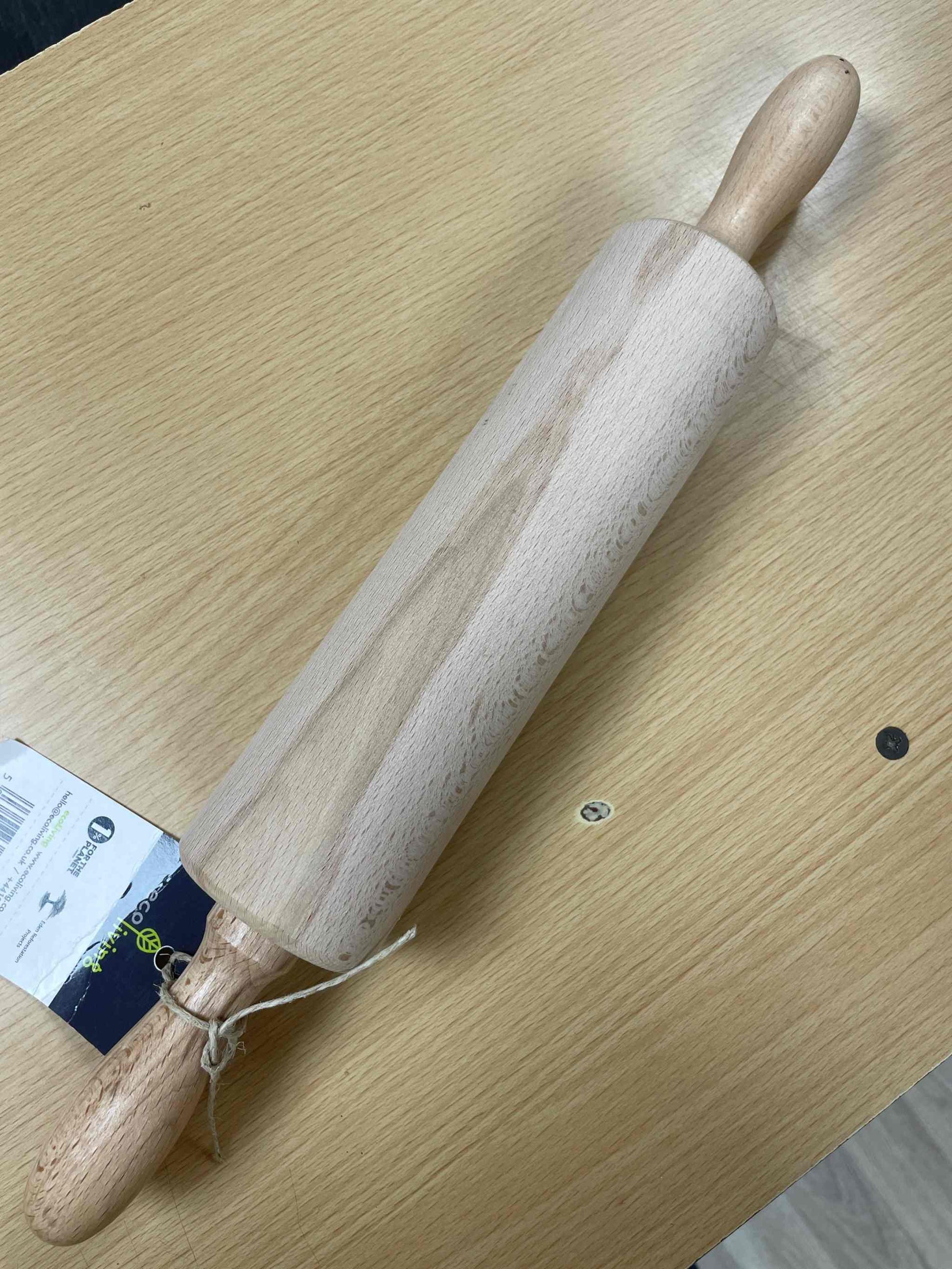 FSC wooden rolling pin on a wooden surface displaying ergonomic design and natural wood grain.