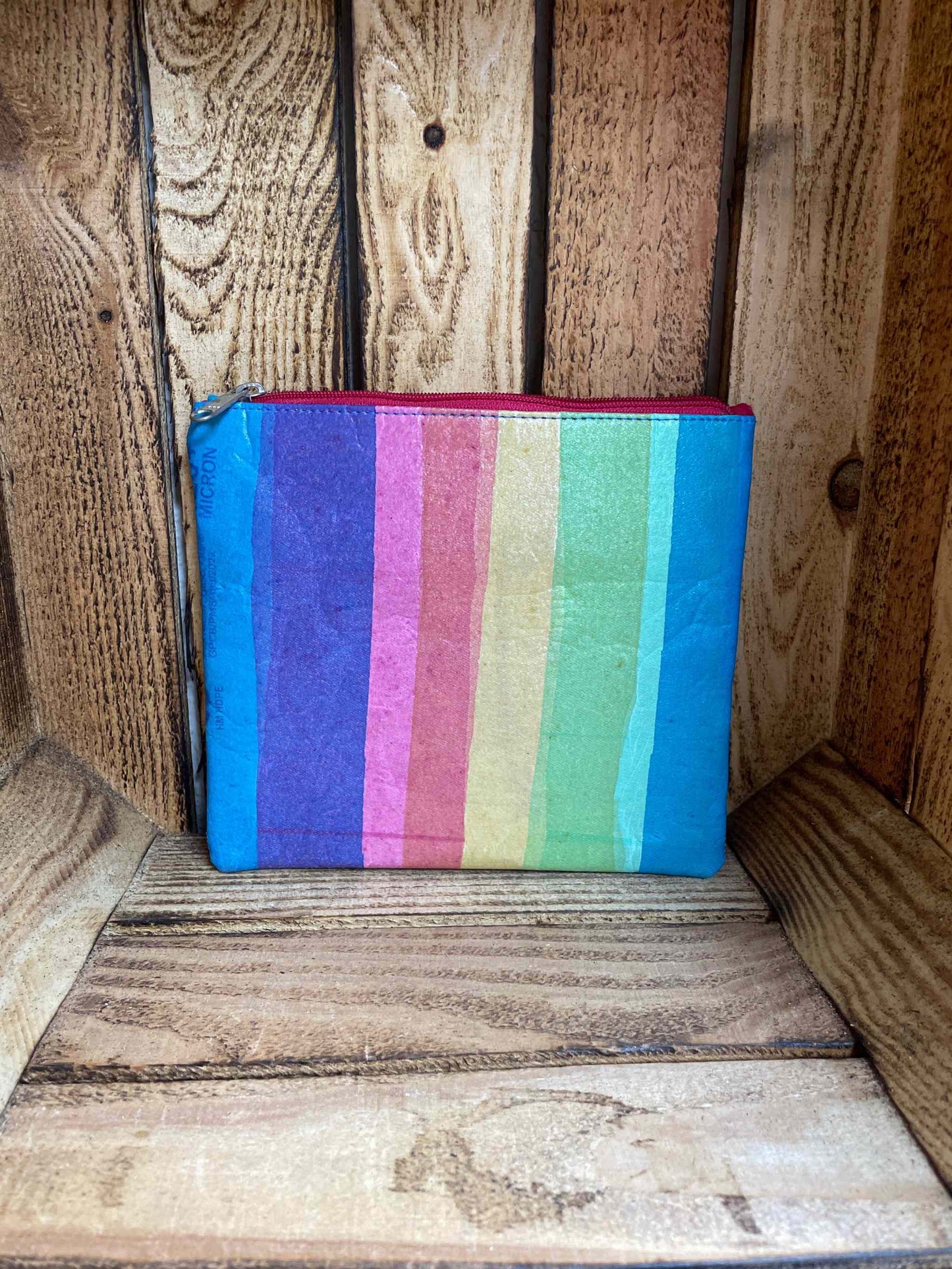 Eco-friendly rainbow pouch made from recycled plastic, vibrant and sustainable accessory.