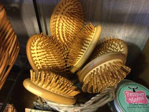 Large bamboo hair brushes with natural bristles displayed in a basket.