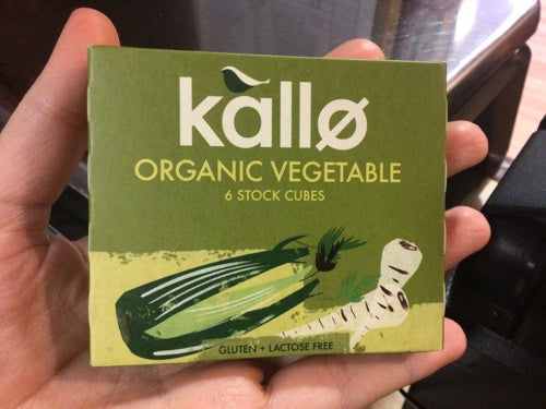 Kallo Organic Vegetable Stock Cubes packaging held in hand, gluten and lactose-free.